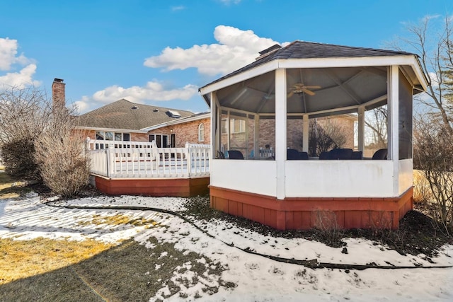 5932 W 75th Pl, Burbank, IL 60459 - view of snowy exterior with a sunroom, a wooden deck, a chimney, and ceiling fan
