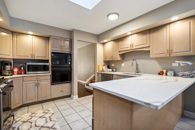 5932 W 75th Pl, Burbank, IL 60459 - kitchen with black appliances, a peninsula, light tile patterned floors, a skylight, and light stone counters