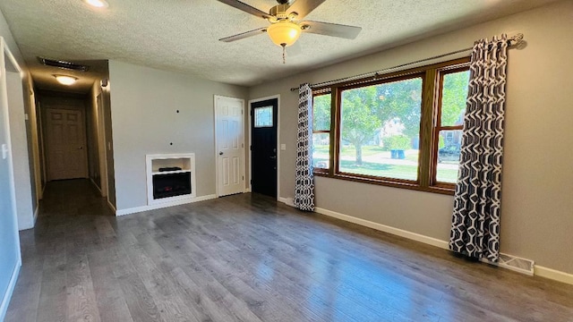 113 E Seminole St, Dwight, IL 60420 - unfurnished living room with a textured ceiling, dark wood-style floors, and ceiling fan