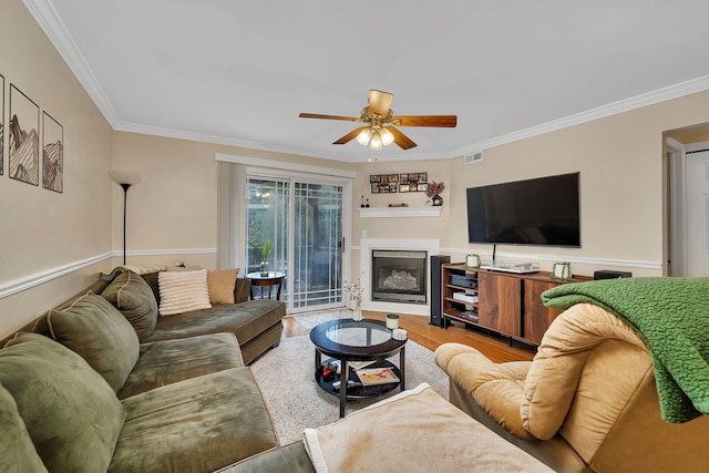 2003 Tall Oaks Dr Unit 2B, Aurora, IL 60505 - living room with a ceiling fan, ornamental molding, light wood-style floors, a glass covered fireplace, and wainscoting