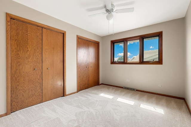 7340 Mimosa Dr, Orland Park, IL 60462 - unfurnished bedroom featuring multiple closets, light carpet, and ceiling fan