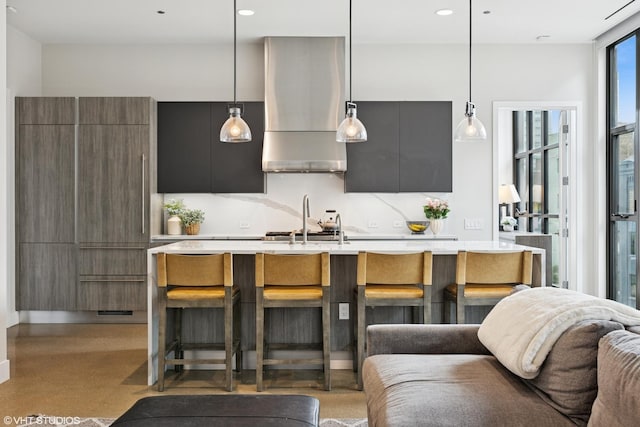 900 W Washington Blvd Unit 404, Chicago, IL 60607 - kitchen featuring wall chimney range hood, modern cabinets, light countertops, a kitchen breakfast bar, and recessed lighting
