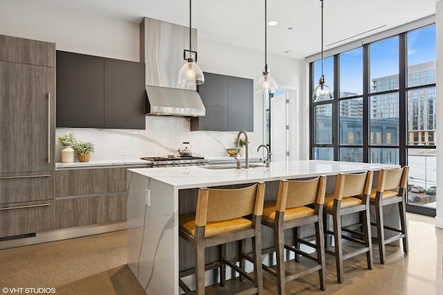 900 W Washington Blvd Unit 404, Chicago, IL 60607 - kitchen with modern cabinets, a kitchen island with sink, a kitchen bar, wall chimney range hood, and a wall of windows