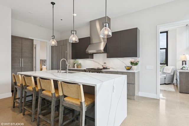 900 W Washington Blvd Unit 404, Chicago, IL 60607 - kitchen with modern cabinets, wall chimney exhaust hood, light stone counters, a breakfast bar area, and decorative light fixtures