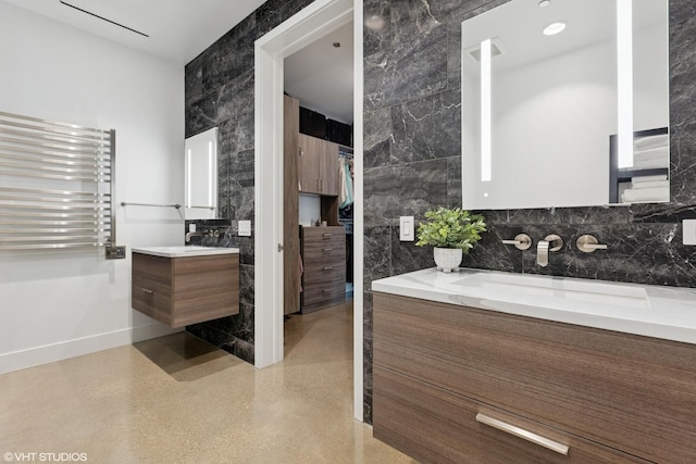 900 W Washington Blvd Unit 404, Chicago, IL 60607 - full bathroom featuring tile walls, radiator, two vanities, a spacious closet, and a towel warming rack