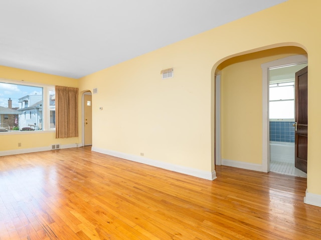 2839 N 75th Ct, Elmwood Park, IL 60707 - empty room with arched walkways, healthy amount of natural light, and light wood finished floors