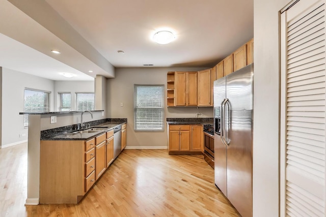4653 N Lawndale Ave Unit 2S, Chicago, IL 60625 - kitchen with stainless steel appliances, open shelves, light wood-type flooring, dark stone counters, and a peninsula