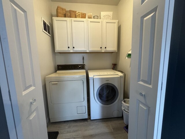 600 W White St, Clinton, IL 61727 - washroom with cabinet space, washing machine and dryer, and wood finished floors