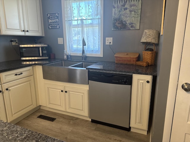 600 W White St, Clinton, IL 61727 - kitchen featuring appliances with stainless steel finishes, wood finished floors, and dark stone counters