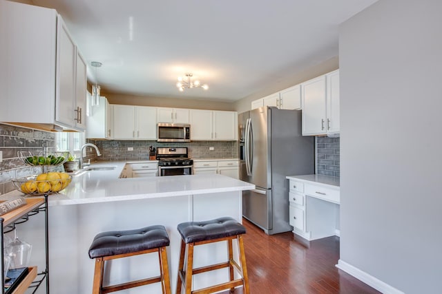1818 Olde Mill Rd, Plainfield, IL 60586 - kitchen with stainless steel appliances, a peninsula, dark wood-type flooring, and decorative backsplash