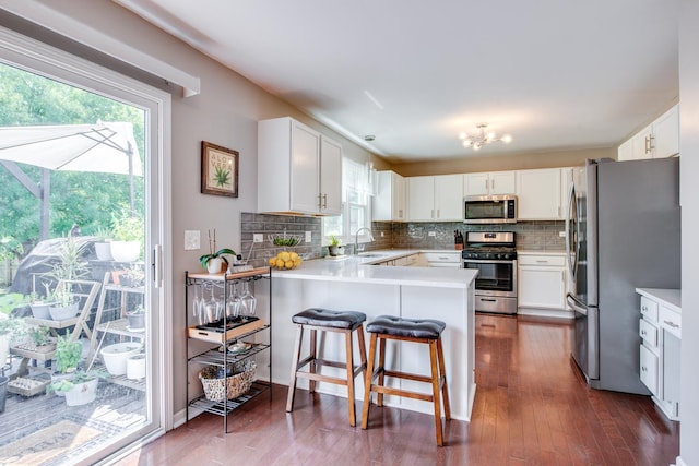 1818 Olde Mill Rd, Plainfield, IL 60586 - kitchen with stainless steel appliances, a peninsula, decorative backsplash, and white cabinetry