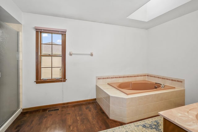 1091 Danforth Dr, Batavia, IL 60510 - full bathroom featuring a skylight, a bath, wood finished floors, and a stall shower