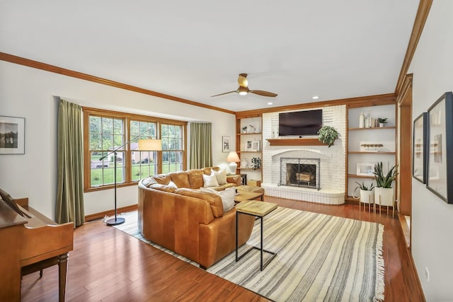 1091 Danforth Dr, Batavia, IL 60510 - living area with wood finished floors, ceiling fan, a brick fireplace, ornamental molding, and recessed lighting