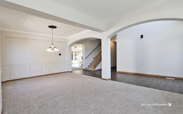 1305 Lilac Ln, Harvard, IL 60033 - spare room with dark carpet, a chandelier, arched walkways, stairway, and ornamental molding
