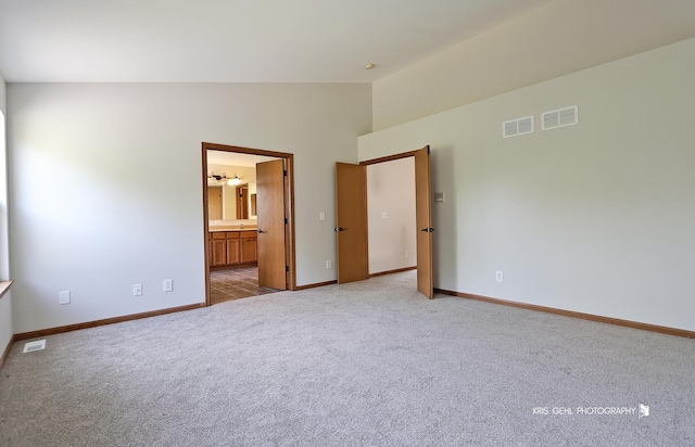 1305 Lilac Ln, Harvard, IL 60033 - unfurnished bedroom with light colored carpet, high vaulted ceiling, and connected bathroom