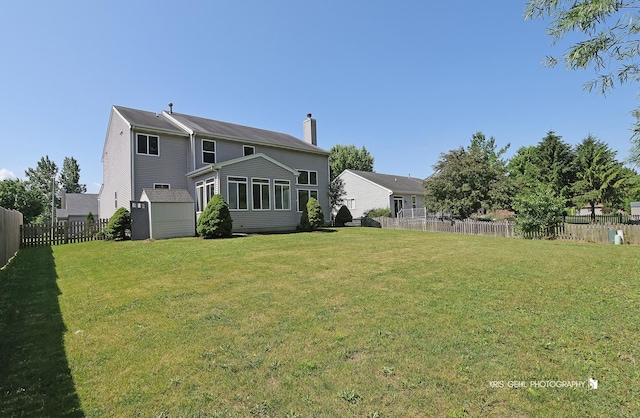 1305 Lilac Ln, Harvard, IL 60033 - back of property with a chimney, a fenced backyard, and a shed