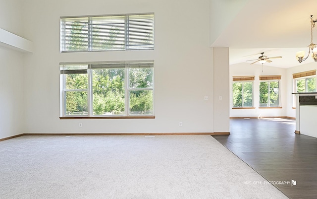 1305 Lilac Ln, Harvard, IL 60033 - unfurnished living room featuring ceiling fan, a towering ceiling, dark colored carpet, and dark wood finished floors