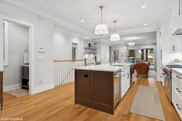 823 W George St Unit 1, Chicago, IL 60657 - kitchen featuring light countertops, white cabinets, light wood-style floors, a center island with sink, and recessed lighting