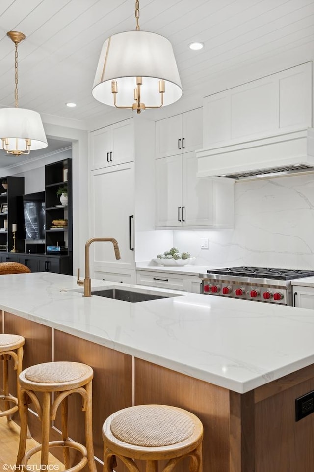 823 W George St Unit 1, Chicago, IL 60657 - kitchen with a chandelier, light stone counters, white cabinets, a breakfast bar area, and recessed lighting