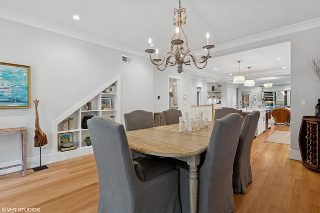 823 W George St Unit 1, Chicago, IL 60657 - dining space featuring a chandelier, light wood-style flooring, recessed lighting, built in features, and crown molding