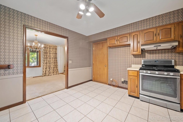 2050 Alschuler Dr, Aurora, IL 60506 - kitchen with gas range, under cabinet range hood, wallpapered walls, a chandelier, and light countertops