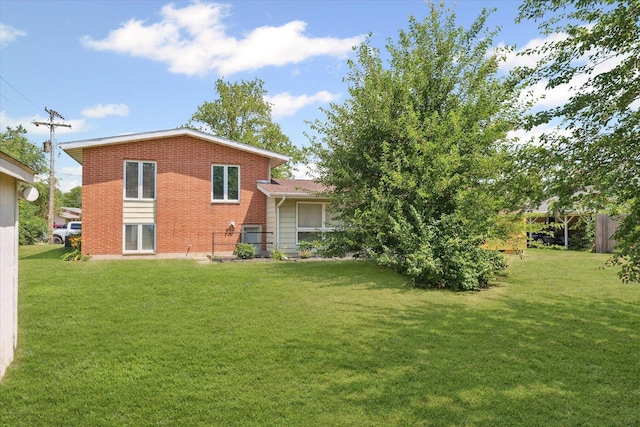 1565 S Pointe Dr, Rantoul, IL 61866 - back of house featuring a yard and brick siding
