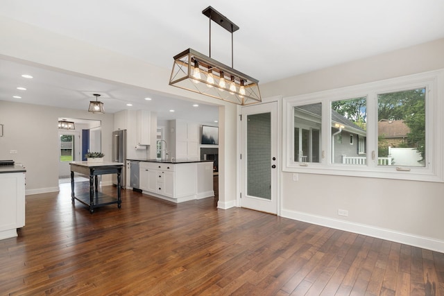 22W672 Elmwood Dr, Glen Ellyn, IL 60137 - kitchen with dark countertops, appliances with stainless steel finishes, white cabinets, dark wood-type flooring, and a chandelier