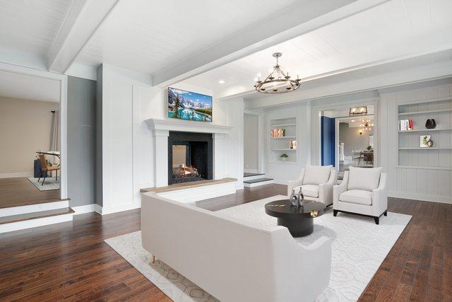 22W672 Elmwood Dr, Glen Ellyn, IL 60137 - living area with beamed ceiling, dark wood-style floors, a multi sided fireplace, a chandelier, and built in shelves
