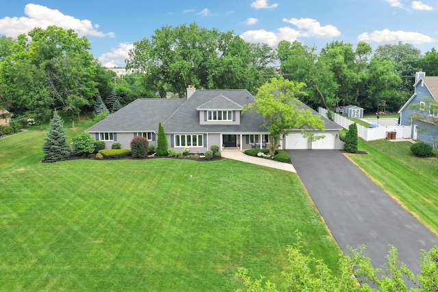 22W672 Elmwood Dr, Glen Ellyn, IL 60137 - view of front of home featuring asphalt driveway, an attached garage, a chimney, and roof with shingles