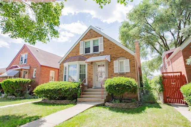 3628 N Oconto Ave, Chicago, IL 60634 - view of front of property featuring a gate, brick siding, and a chimney