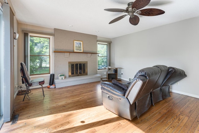 11280 James Ct, Genoa, IL 60135 - living area with hardwood / wood-style flooring, ceiling fan, and a brick fireplace