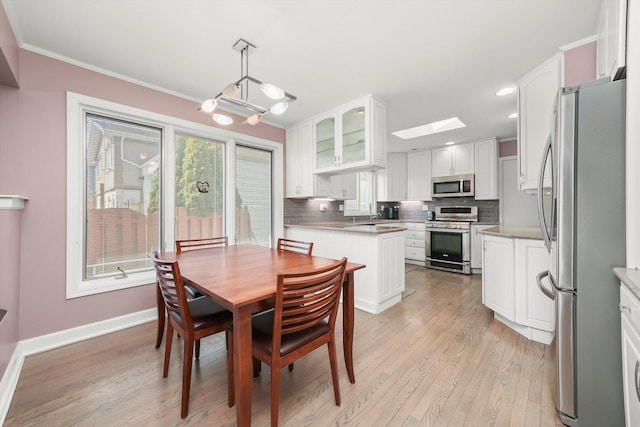 905 W Palm Dr, Mount Prospect, IL 60056 - dining space with light wood finished floors, a skylight, crown molding, and recessed lighting
