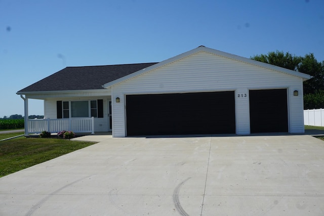 ranch-style home with an attached garage, covered porch, concrete driveway, and a shingled roof