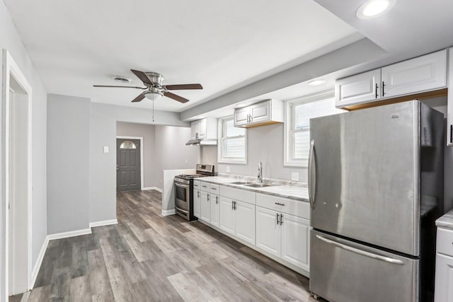 9720 S Exchange Ave, Chicago, IL 60617 - kitchen with stainless steel appliances, a ceiling fan, under cabinet range hood, and white cabinetry