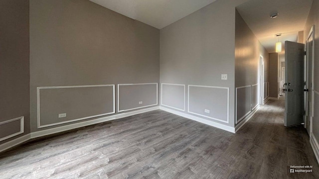 5738 S Carpenter St, Chicago, IL 60621 - empty room featuring lofted ceiling, wood finished floors, a decorative wall, and wainscoting