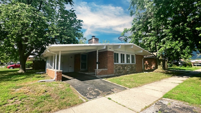 15043 Meadow Ln, Dolton, IL 60419 - view of front of house with driveway, a carport, a front lawn, a chimney, and brick siding