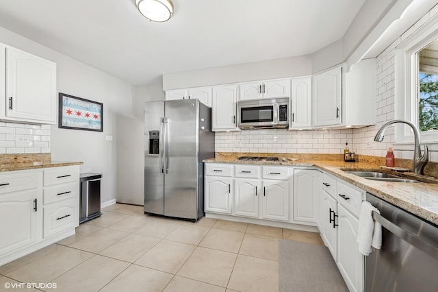 1426 E Kenilworth Ave, Palatine, IL 60074 - kitchen featuring appliances with stainless steel finishes, decorative backsplash, light stone counters, and white cabinetry