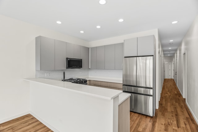4316 S Michigan Ave Unit 1S, Chicago, IL 60653 - kitchen featuring stainless steel fridge, gray cabinets, gas range, a peninsula, and light countertops