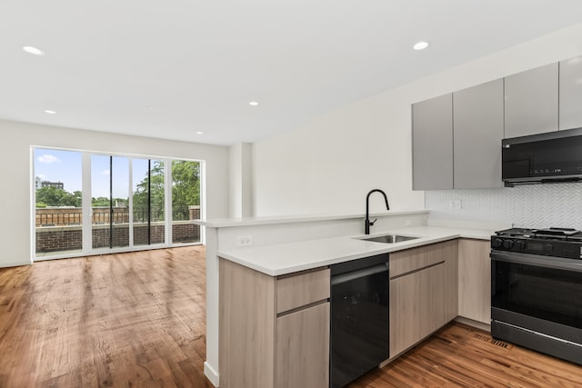 4316 S Michigan Ave Unit 1S, Chicago, IL 60653 - kitchen featuring stainless steel gas range oven, black dishwasher, a peninsula, light countertops, and wood finished floors