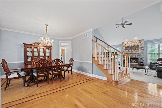 1108 Independence Ave, Elburn, IL 60119 - dining room featuring a fireplace, stairway, ceiling fan, wood finished floors, and a chandelier