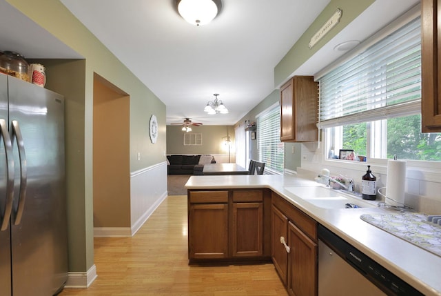 710 Cimarron Dr, Cary, IL 60013 - kitchen featuring appliances with stainless steel finishes, light wood-type flooring, open floor plan, light countertops, and a peninsula