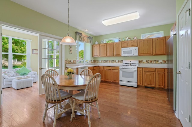12856 W Rocksprings Ln, Huntley, IL 60142 - kitchen featuring white appliances, light countertops, light wood-style floors, and plenty of natural light