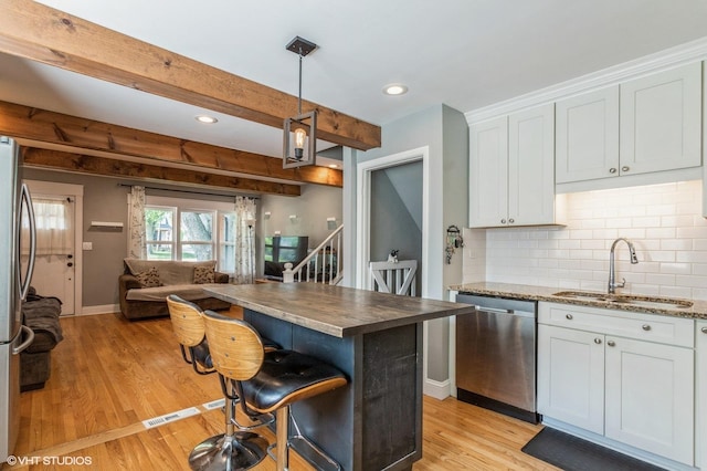 26W323 Harrison Ave, Winfield, IL 60190 - kitchen featuring stainless steel appliances, open floor plan, light wood-style floors, decorative backsplash, and white cabinetry