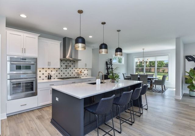 0N337 Herrick Dr, Wheaton, IL 60187 - kitchen with wall chimney exhaust hood, appliances with stainless steel finishes, light wood-style floors, light countertops, and decorative backsplash