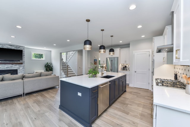 0N337 Herrick Dr, Wheaton, IL 60187 - kitchen featuring appliances with stainless steel finishes, open floor plan, white cabinetry, light wood finished floors, and light countertops