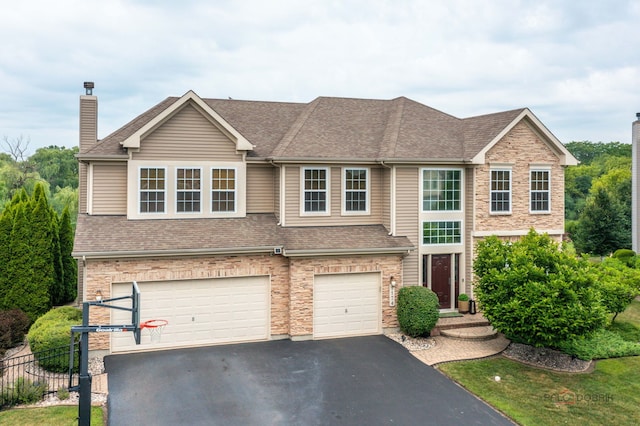 1174 Pine Tree Ct, Lake Villa, IL 60046 - view of front facade with asphalt driveway, an attached garage, a shingled roof, and a chimney
