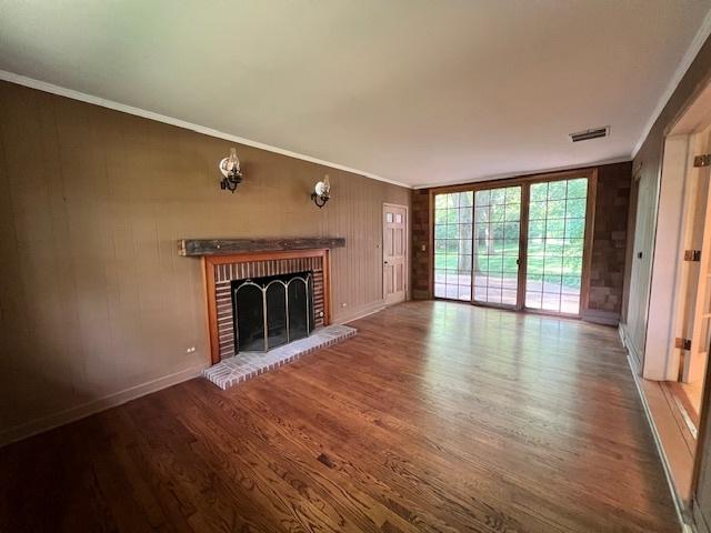 1917 Thornhill Rd, Inverness, IL 60067 - unfurnished living room featuring wood finished floors, a fireplace, crown molding, and wooden walls