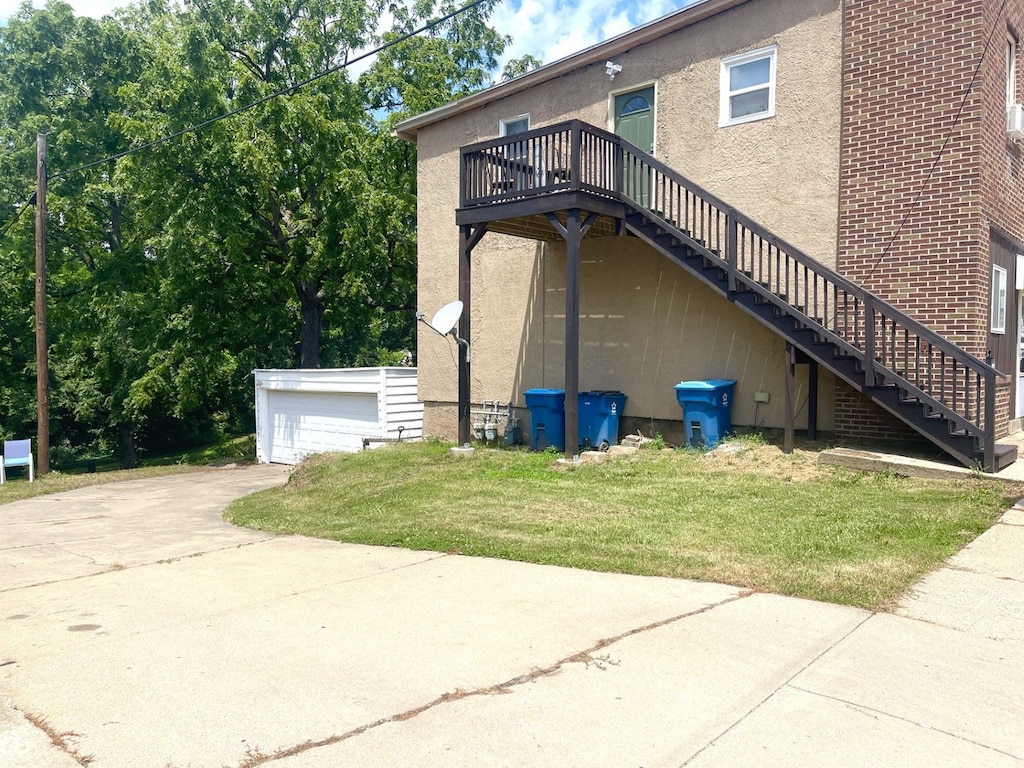 314 Peru St, Peru, IL 61354 - view of home's exterior with stairway, stucco siding, a yard, and a wooden deck