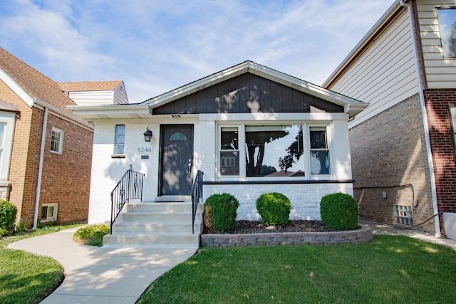 5246 N Mason Ave, Chicago, IL 60630 - view of front of home with a front yard, brick siding, and board and batten siding