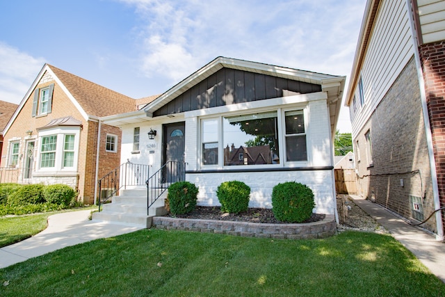 5246 N Mason Ave, Chicago, IL 60630 - view of front facade with a front lawn, brick siding, and board and batten siding